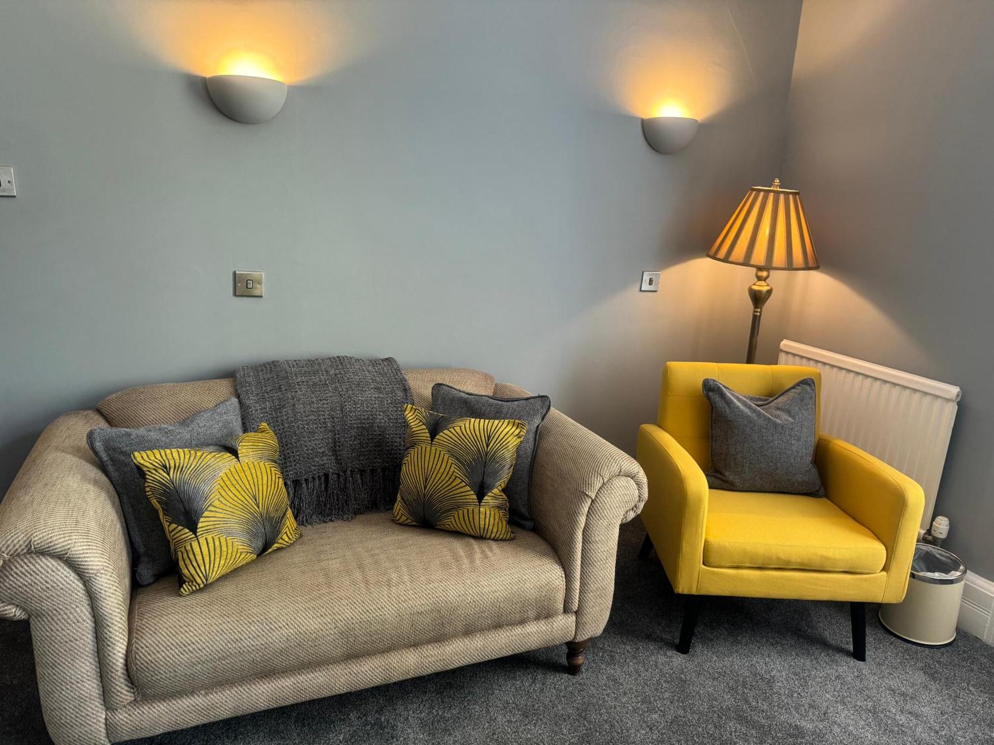 The Red Lion Hotel Кромер Экстерьер фото A living room with a sofa and a chair
